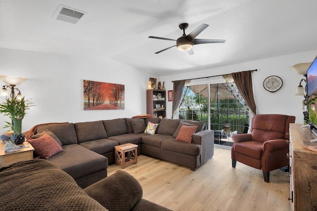 living room with ceiling fan, light wood-type flooring, and vaulted ceiling