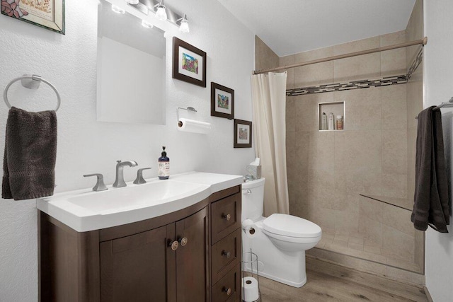 bathroom with hardwood / wood-style flooring, vanity, curtained shower, and toilet