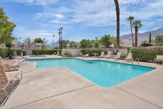 view of swimming pool with a mountain view and a patio