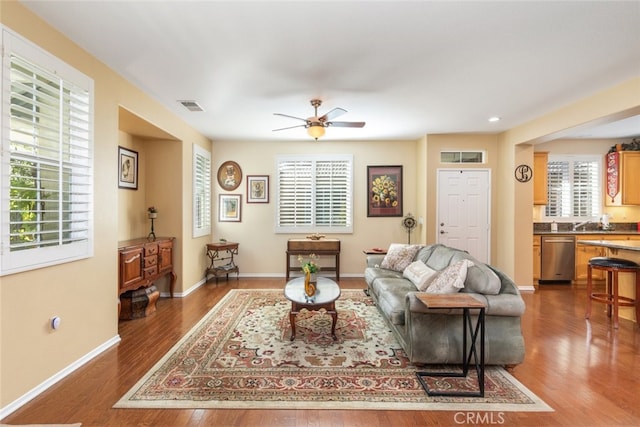 living room featuring ceiling fan and dark hardwood / wood-style flooring