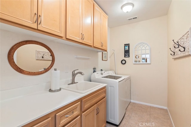 washroom with cabinets, independent washer and dryer, sink, and light tile patterned floors