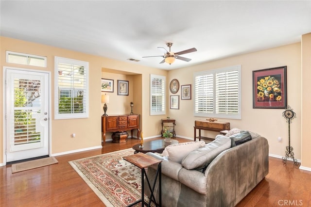 living room with ceiling fan and dark wood-type flooring