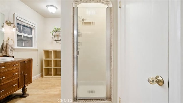 bathroom featuring hardwood / wood-style floors, vanity, and walk in shower