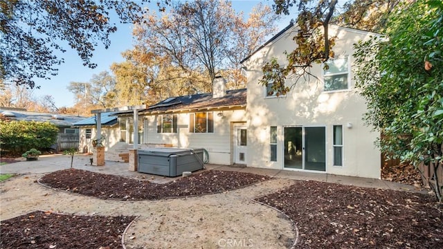 rear view of house with a patio and a hot tub