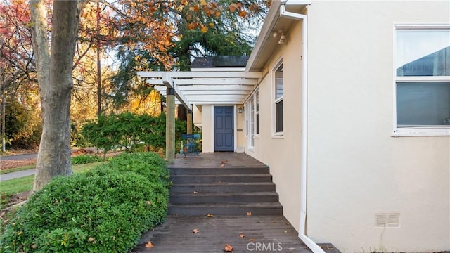 view of exterior entry featuring a pergola