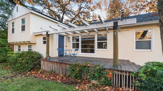 back of property with a pergola and a wooden deck