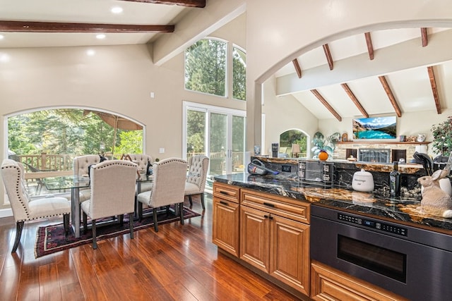 kitchen featuring plenty of natural light, beamed ceiling, and dark wood-type flooring