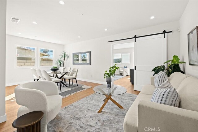 living room featuring light wood-type flooring and a barn door