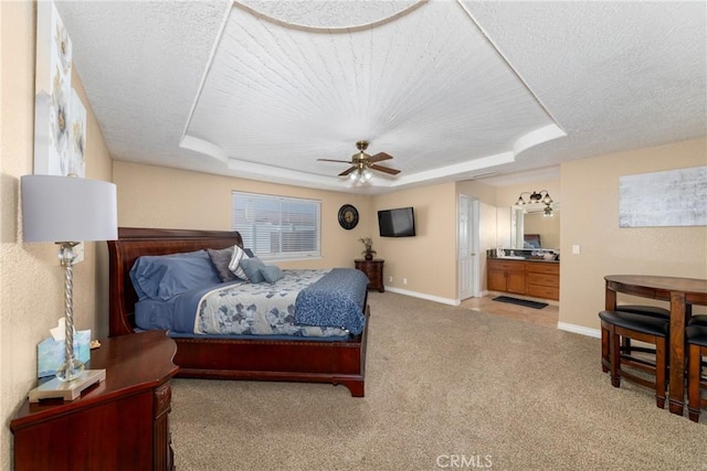 bedroom featuring a tray ceiling, ceiling fan, light carpet, and a textured ceiling