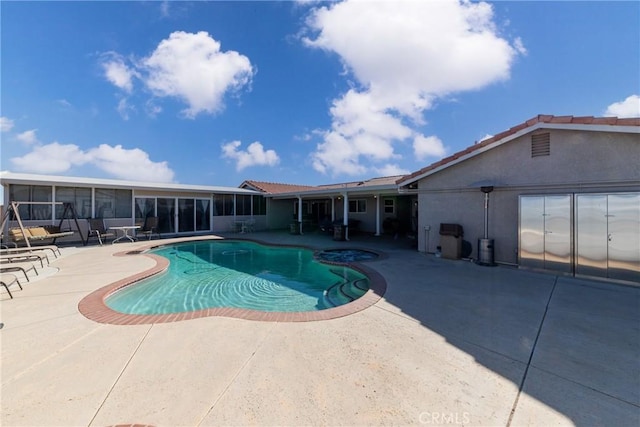 view of swimming pool featuring a sunroom and a patio