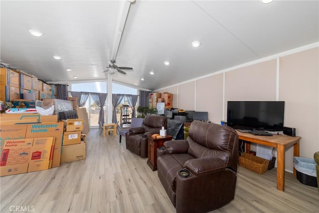 living room with ceiling fan, light hardwood / wood-style flooring, and vaulted ceiling