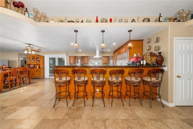 bar with hanging light fixtures and ceiling fan