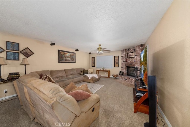 living room with ceiling fan, carpet floors, a textured ceiling, and a brick fireplace