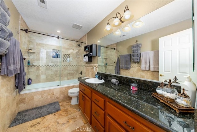 full bathroom with vanity, bath / shower combo with glass door, and toilet