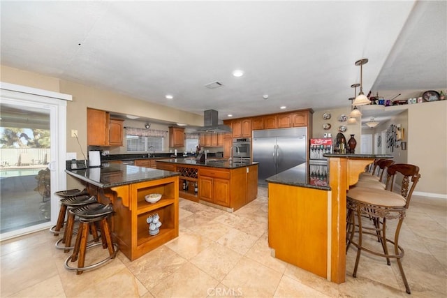 kitchen with a breakfast bar, a center island, stainless steel appliances, and decorative light fixtures