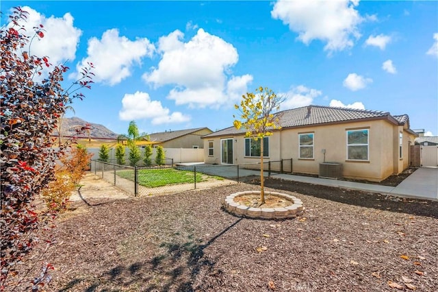 back of house with central AC unit, a patio, and a mountain view