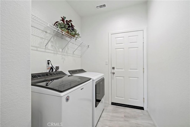 clothes washing area featuring independent washer and dryer