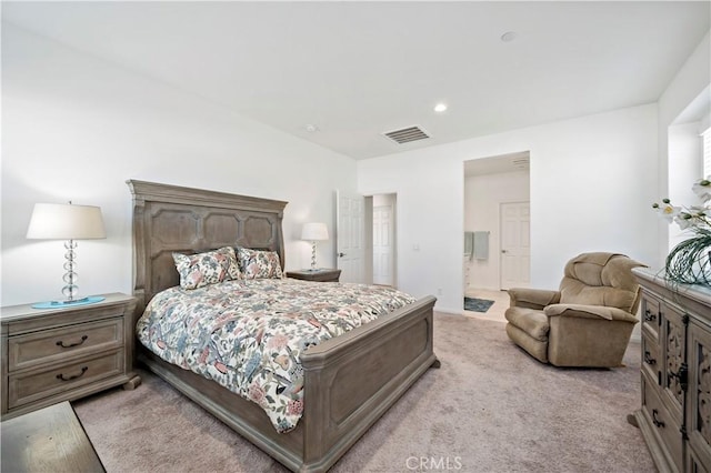 bedroom with light colored carpet and connected bathroom