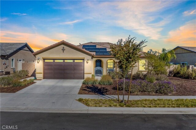 view of front of home featuring solar panels and a garage