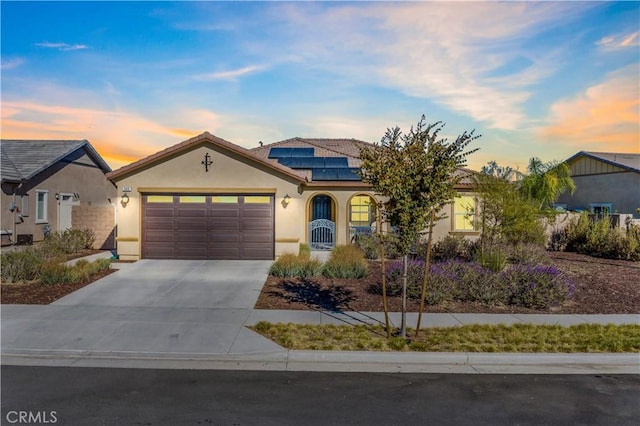 view of front of house with a garage and solar panels