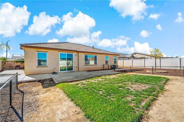 back of house featuring a yard and a patio area