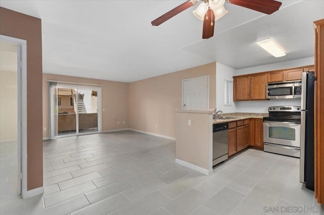 kitchen with ceiling fan, sink, light tile patterned floors, and stainless steel appliances