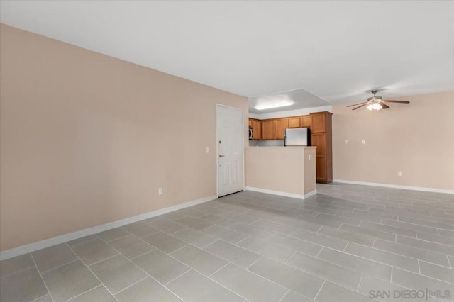 unfurnished living room featuring ceiling fan and light tile patterned flooring