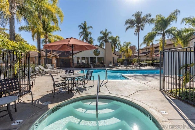 view of swimming pool with a patio and a hot tub