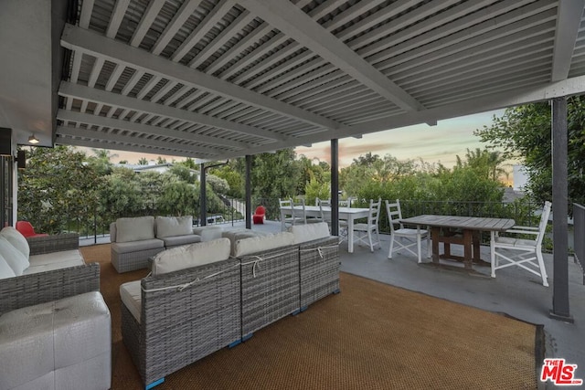 patio terrace at dusk with outdoor lounge area and a baseboard radiator