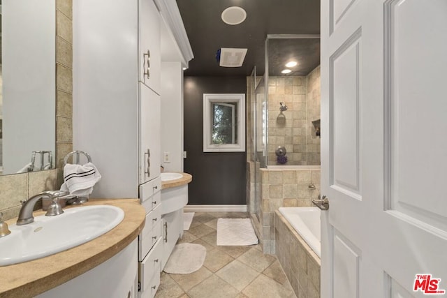 bathroom with tile patterned floors, vanity, and shower with separate bathtub