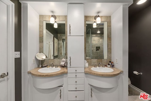 bathroom with vanity, toilet, and backsplash