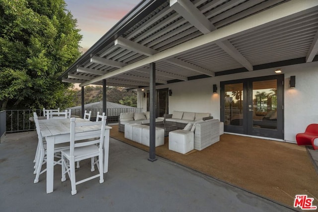 patio terrace at dusk with an outdoor hangout area and french doors