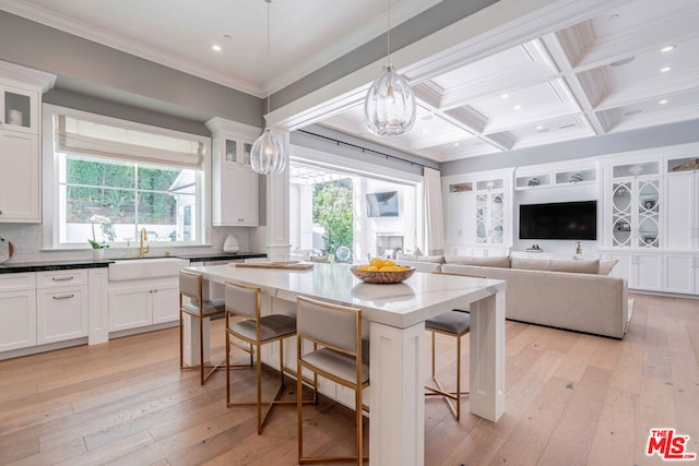 kitchen with a kitchen bar, light wood-type flooring, and a wealth of natural light