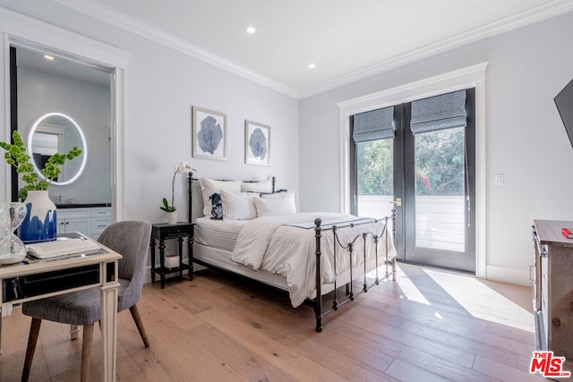 bedroom featuring light wood-type flooring, ornamental molding, access to outside, and french doors