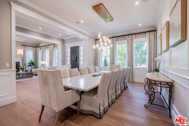 dining room featuring light hardwood / wood-style flooring and crown molding