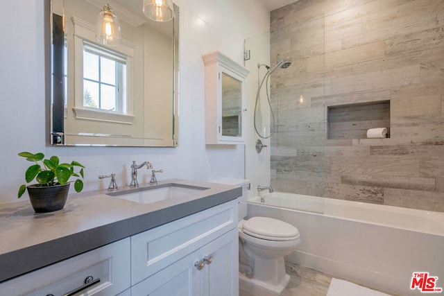 full bathroom with vanity, tiled shower / bath combo, and toilet