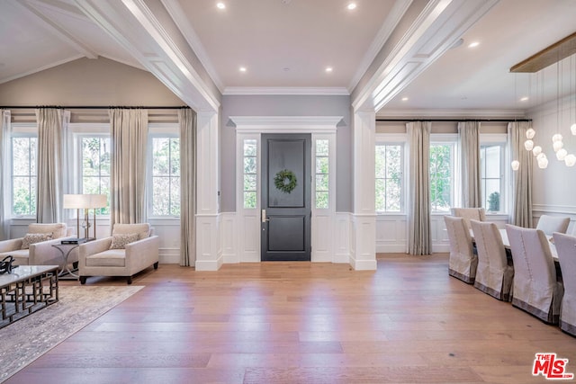 foyer featuring ornate columns, crown molding, light hardwood / wood-style floors, and lofted ceiling with beams