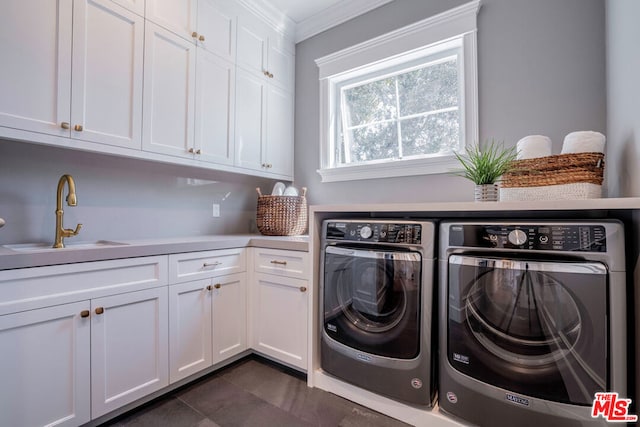 washroom featuring cabinets, ornamental molding, sink, dark tile patterned flooring, and washing machine and dryer