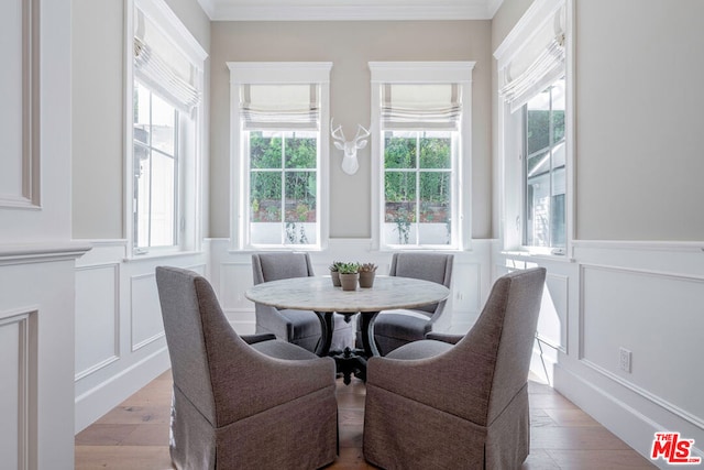 dining room with light hardwood / wood-style flooring, a healthy amount of sunlight, and crown molding