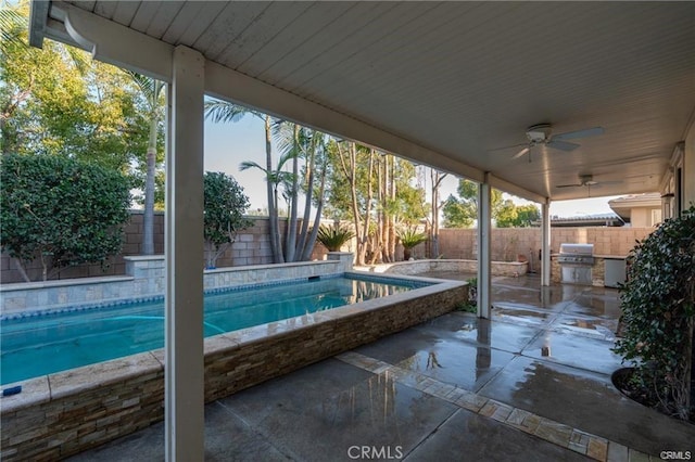 view of swimming pool featuring area for grilling, ceiling fan, and a patio area