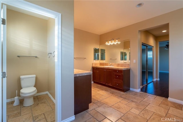 bathroom with vanity, toilet, and ceiling fan