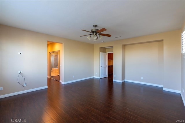 spare room featuring ceiling fan and dark wood-type flooring