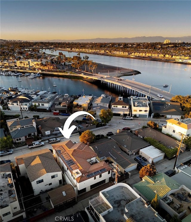 aerial view at dusk featuring a water view