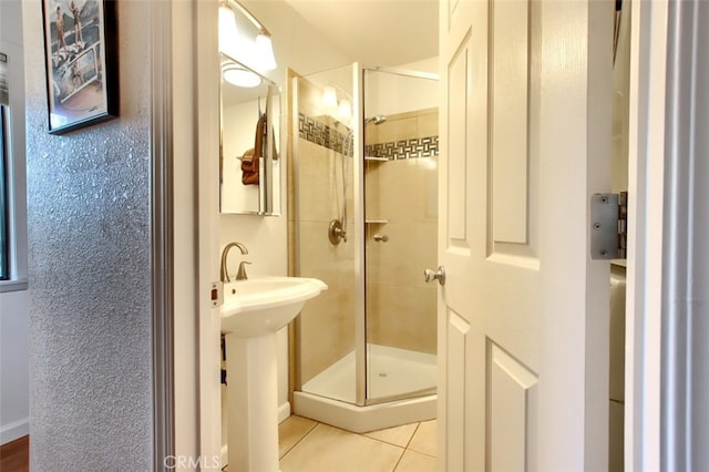 bathroom featuring tile patterned floors and a shower with shower door