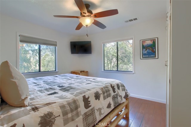 bedroom with dark hardwood / wood-style floors and ceiling fan