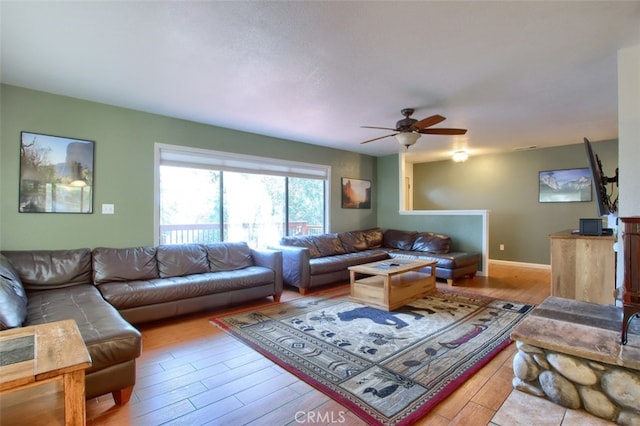 living room featuring ceiling fan and light hardwood / wood-style floors