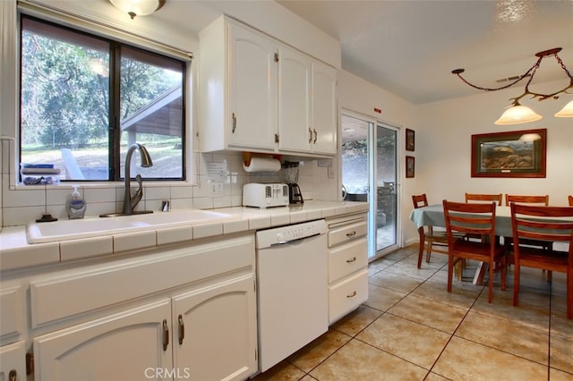 kitchen featuring tile counters, sink, white dishwasher, decorative backsplash, and white cabinets