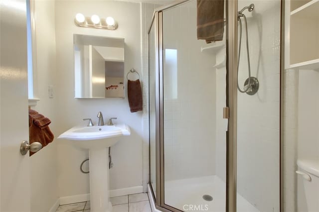 bathroom featuring tile patterned floors, toilet, a shower with shower door, and sink