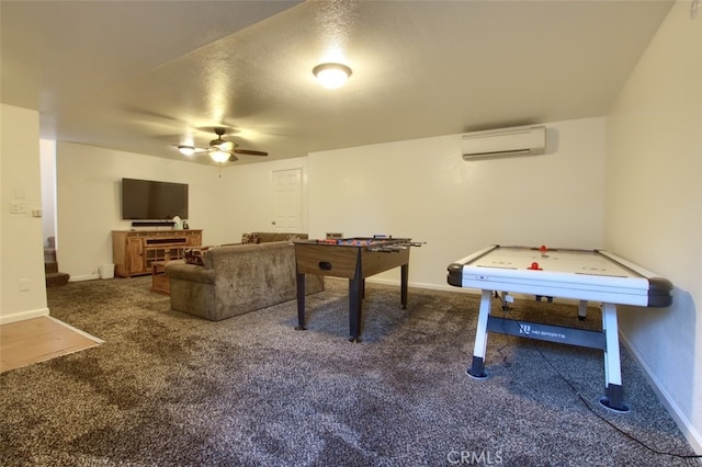 game room with a wall mounted air conditioner, ceiling fan, carpet flooring, and a textured ceiling