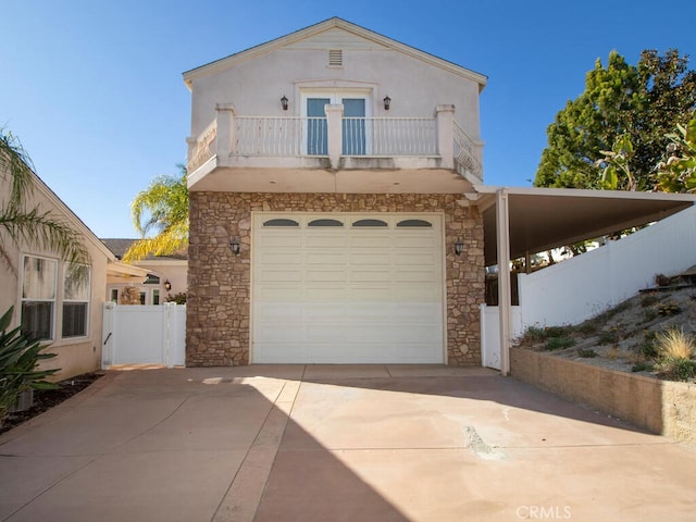 view of front of property with a balcony, a garage, and a carport